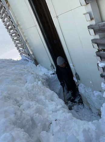倉庫扉前の雪を掻き出す様子